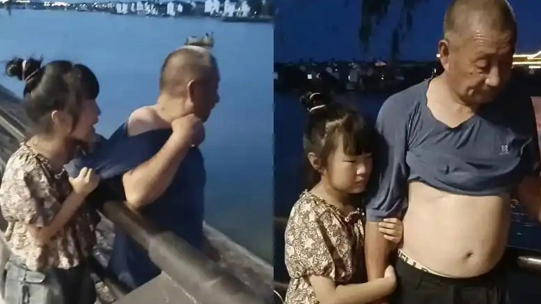 爷爷想下河捞玩具被孙女紧紧拉住